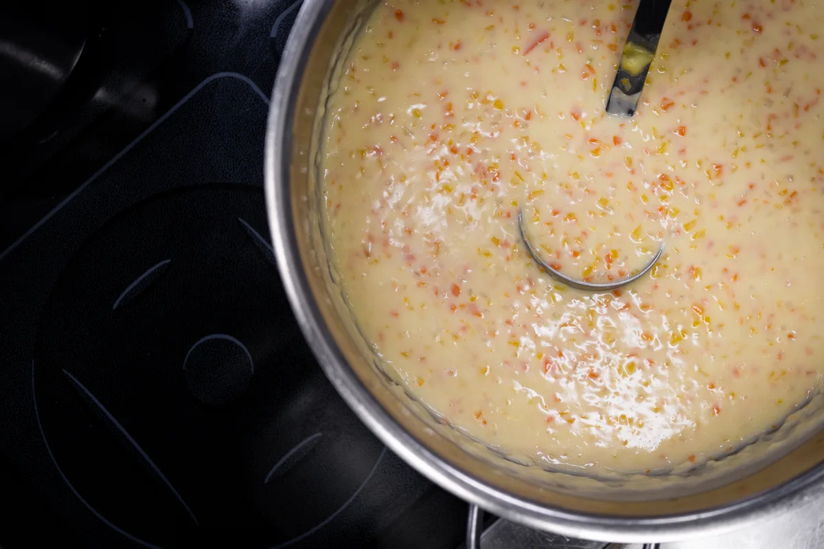 Topf mit einer Suppe mit kleingeschnittenem Gemüse. 
